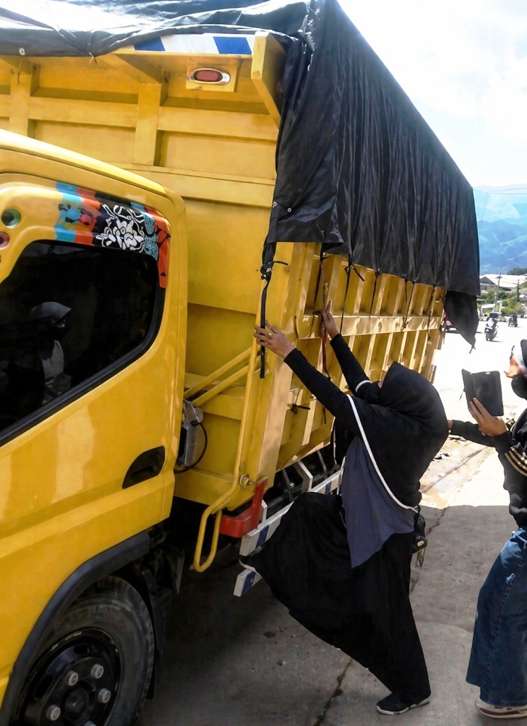 Sekelompok ibu-ibu nekat memanjat badan truk bertutup terpal yang diam-diam mengangkut batu bara dalam aksi blokade di Simpang Batu Kajang, Kabupaten Paser, Kalimantan Timur, pertengahan 2025. Foto: Dok.Ekspos 