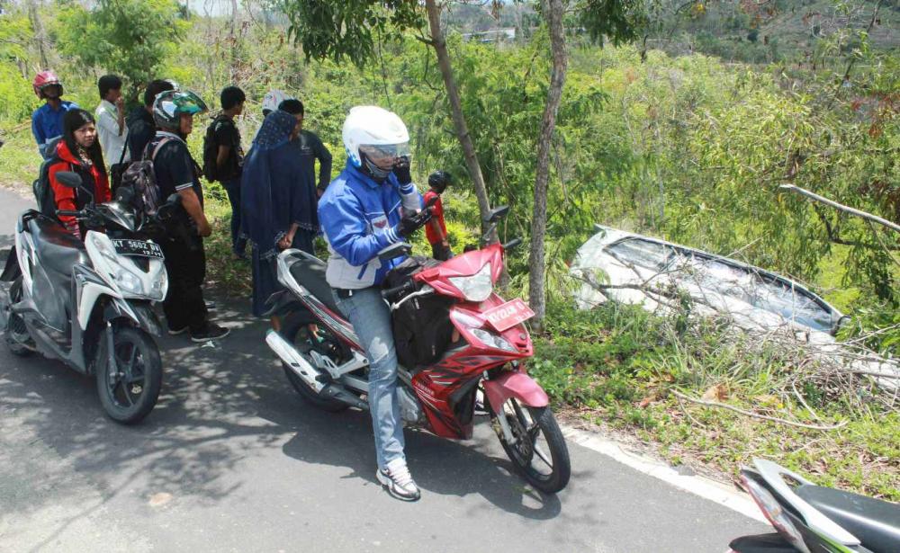 ALAMI PECAH BAN, SEBUAH MOBIL TOYOTA INNOVA WARNA PUTIH HANTAM POHON DIPINGGIR JURANG 